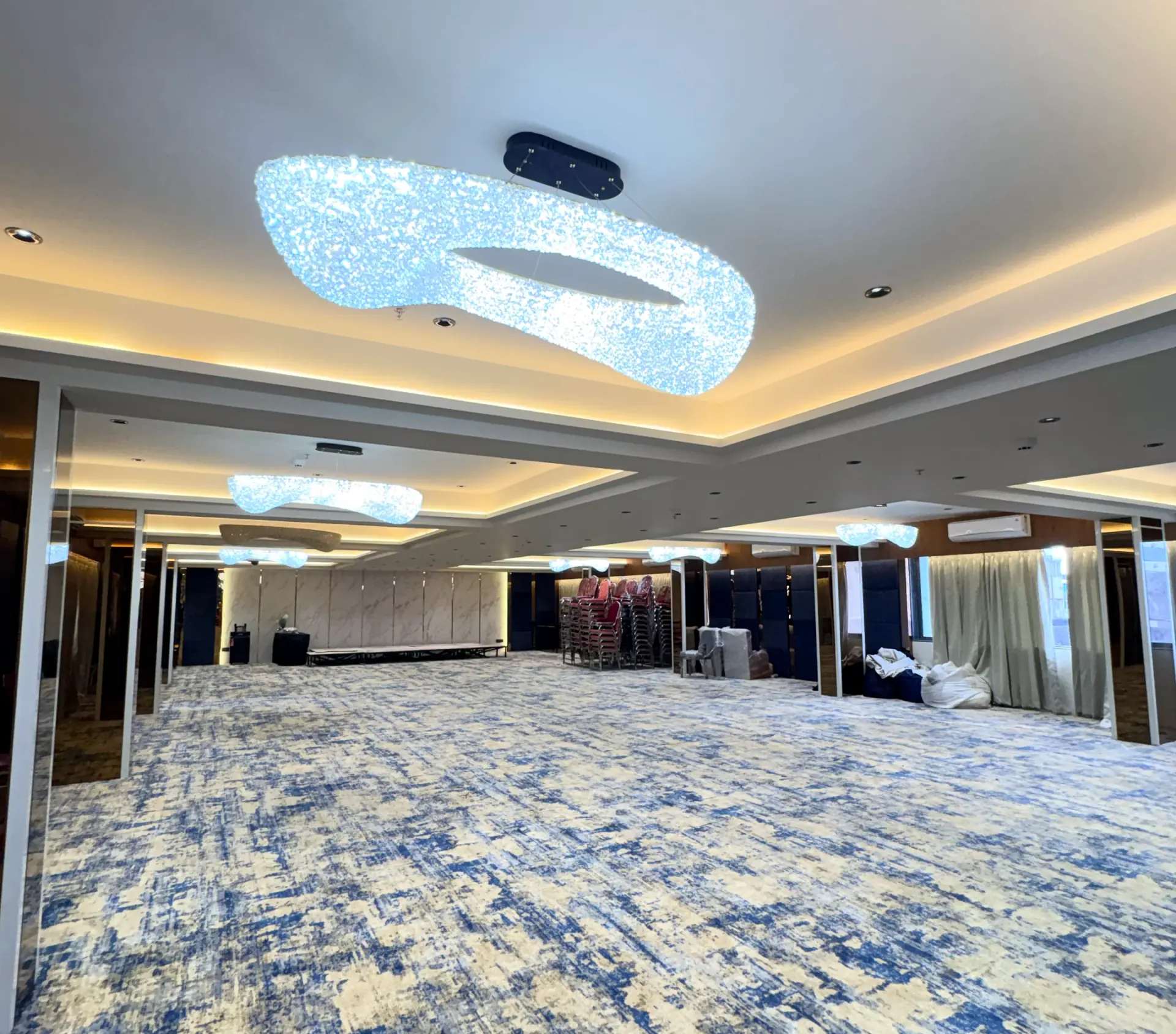 The banquet hall, crystal ceiling fittings above a patterned carpet