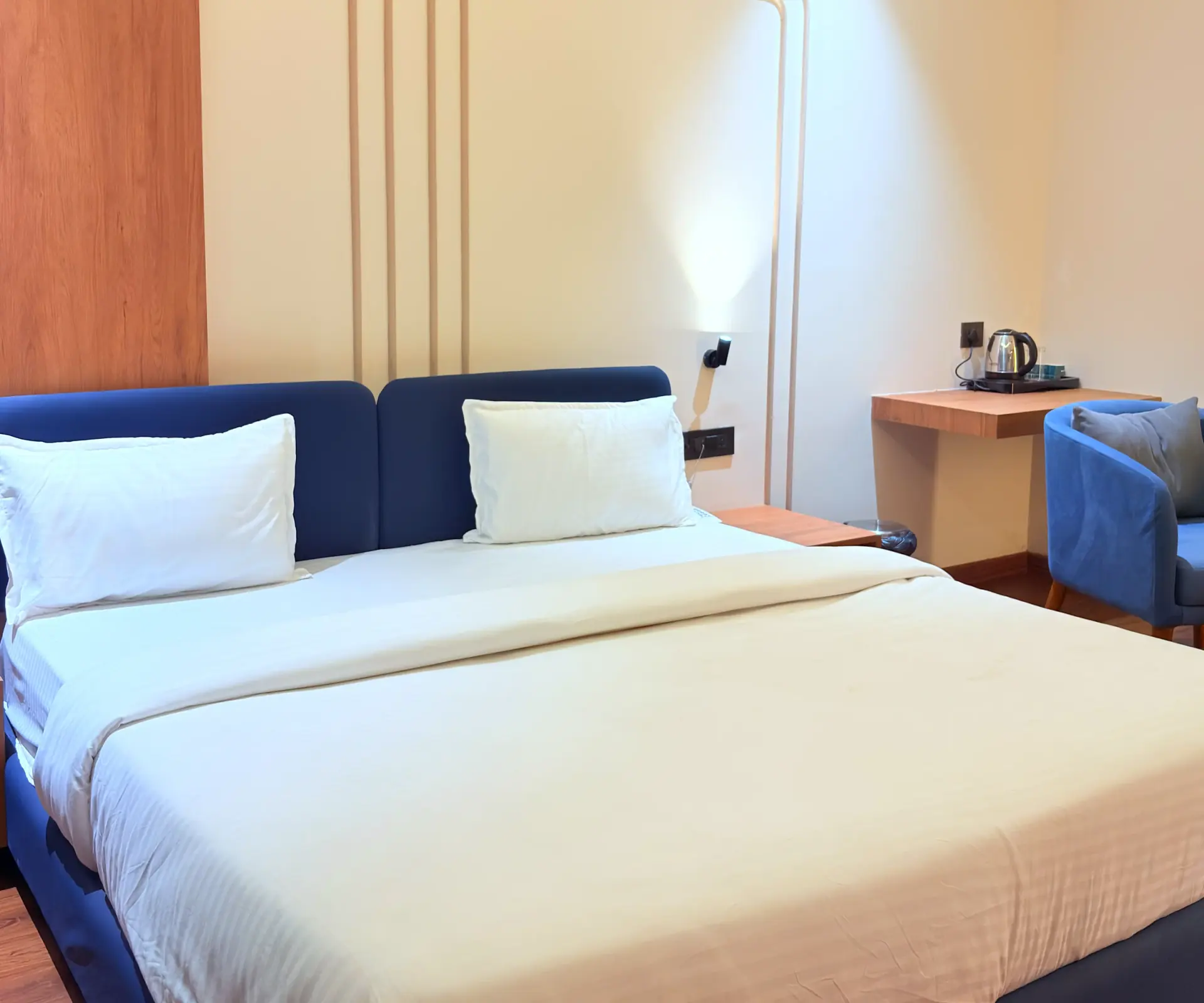 Deluxe Room with a double bed, navy headboard and a work desk