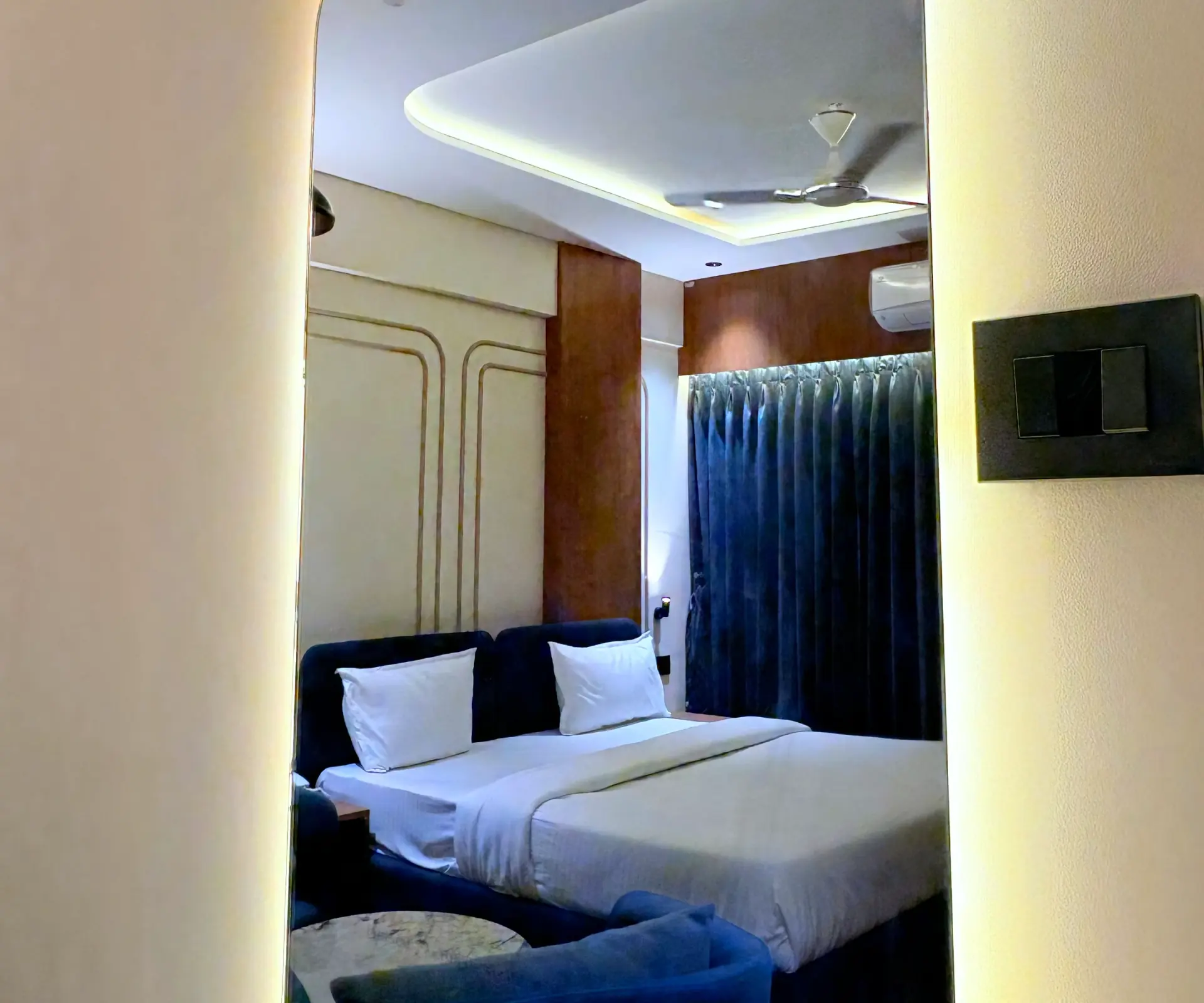 Standard Room with a double bed, navy headboard and blue curtains